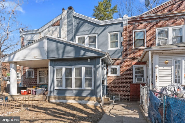 back of house featuring cooling unit, fence, brick siding, and stucco siding