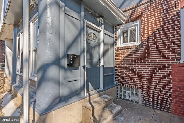 entrance to property featuring brick siding