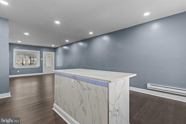 interior space with light stone counters, a center island, recessed lighting, baseboards, and dark wood-style flooring