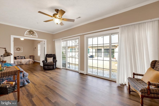 sitting room featuring ceiling fan, visible vents, wood finished floors, and crown molding