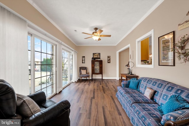 living room with baseboards, crown molding, a ceiling fan, and wood finished floors