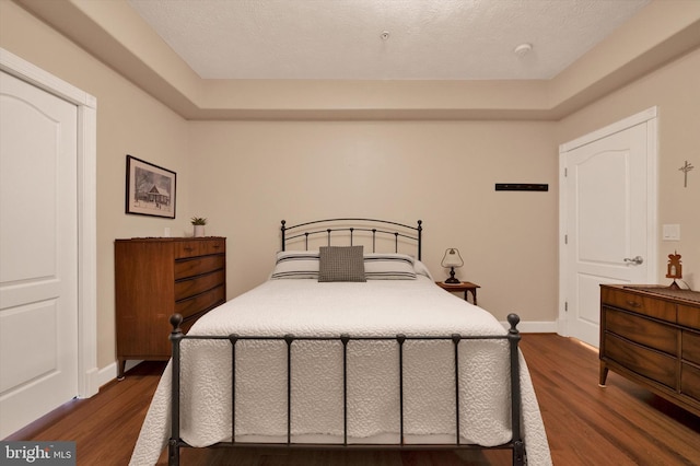 bedroom featuring dark wood-type flooring and baseboards