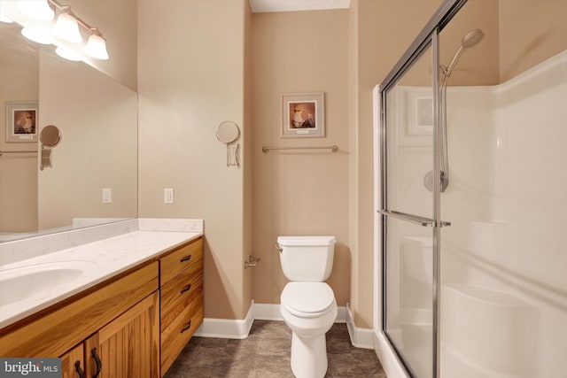 full bath featuring vanity, a shower stall, toilet, and baseboards