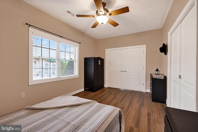 bedroom featuring wood finished floors, visible vents, a closet, and ceiling fan