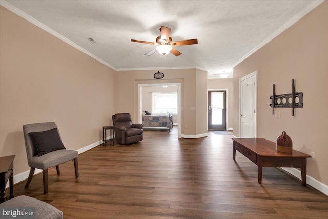 living area featuring visible vents, baseboards, dark wood-style flooring, ceiling fan, and crown molding