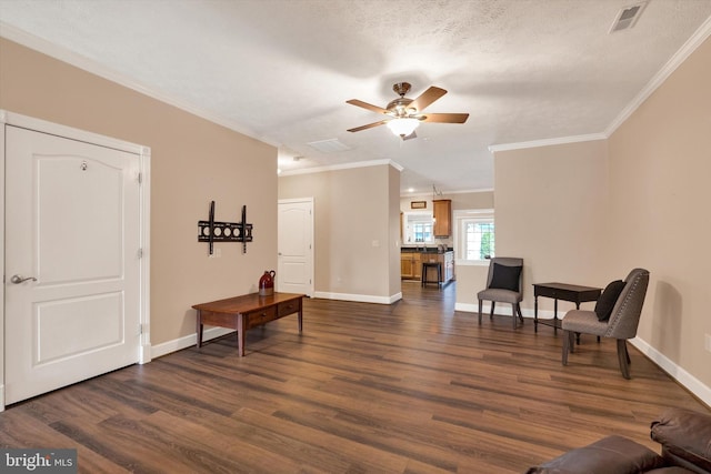 sitting room with visible vents, ornamental molding, a ceiling fan, and dark wood-style flooring