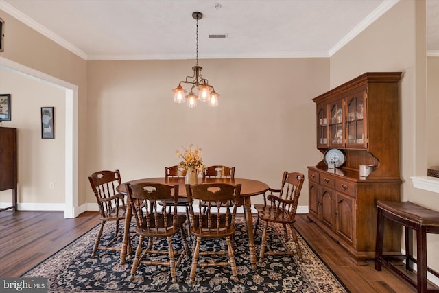 dining area featuring visible vents, a chandelier, dark wood-style flooring, and crown molding