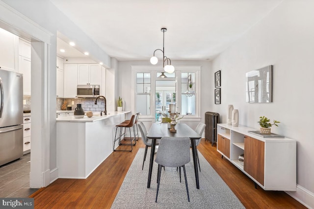 dining space featuring recessed lighting, dark wood-type flooring, and baseboards