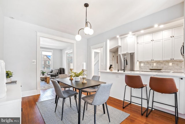 dining space featuring baseboards and dark wood-type flooring