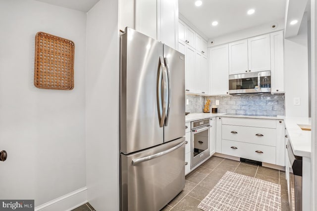 kitchen featuring backsplash, white cabinetry, recessed lighting, stainless steel appliances, and light countertops