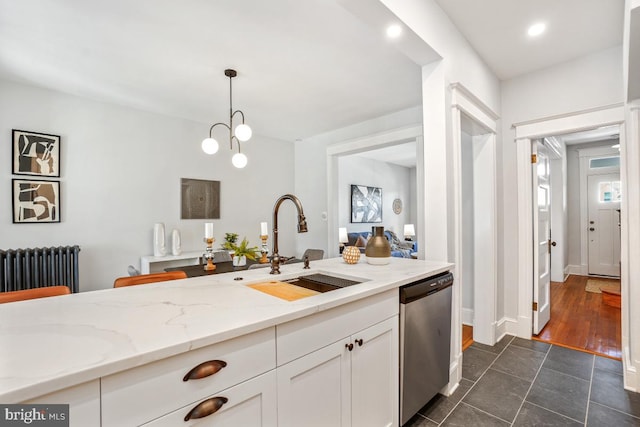 kitchen with decorative light fixtures, stainless steel dishwasher, white cabinetry, radiator, and light stone countertops