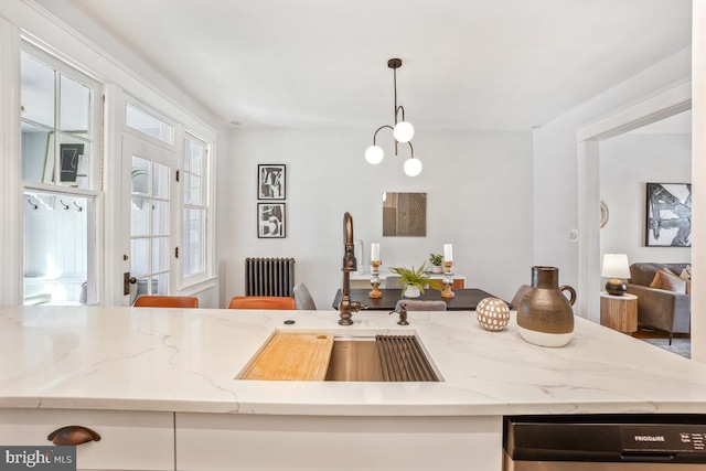 kitchen featuring light stone counters, decorative light fixtures, open floor plan, radiator, and dishwasher