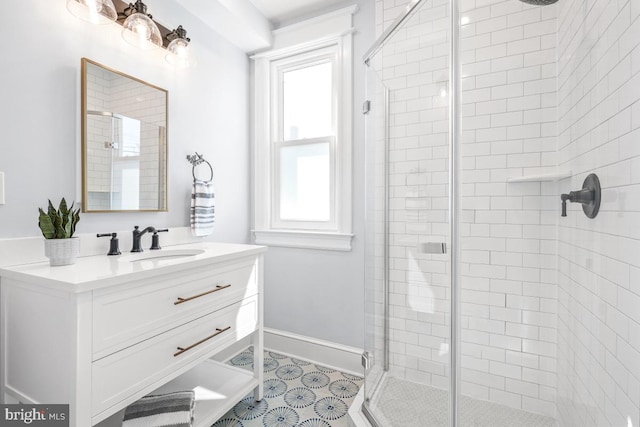 full bath with baseboards, a stall shower, and vanity