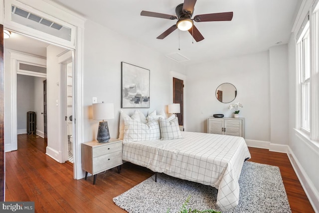 bedroom with visible vents, baseboards, dark wood-type flooring, and ceiling fan