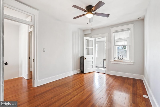 unfurnished bedroom with a ceiling fan, baseboards, and wood-type flooring