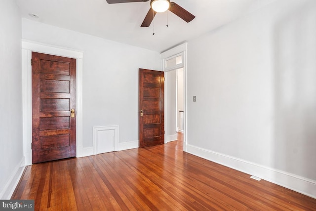 empty room featuring hardwood / wood-style flooring, a ceiling fan, and baseboards