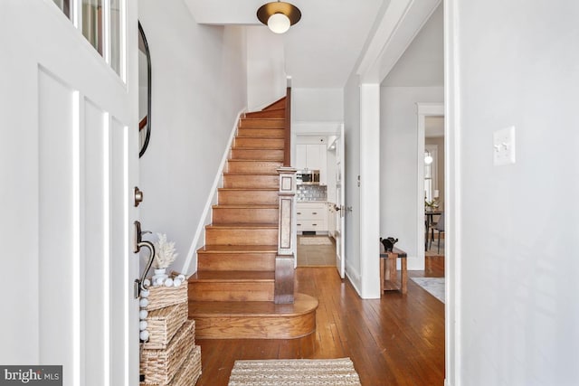 entryway featuring dark wood finished floors and stairs