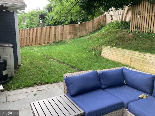 view of yard featuring a patio, a fenced backyard, and an outdoor living space