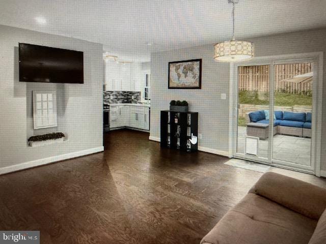 unfurnished living room with baseboards and dark wood-style flooring