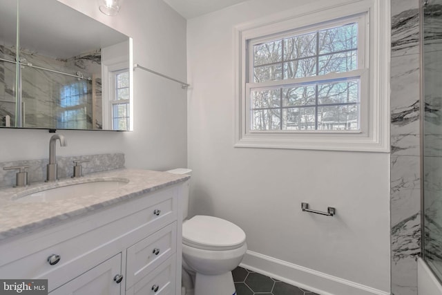 bathroom featuring a marble finish shower, plenty of natural light, baseboards, and vanity