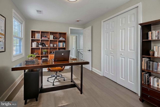 office space with visible vents, baseboards, and wood finished floors