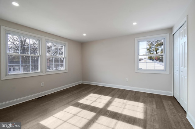 unfurnished bedroom with recessed lighting, baseboards, and dark wood-style floors