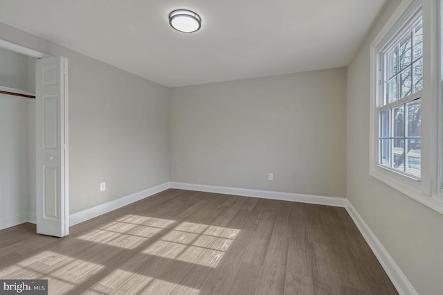 unfurnished bedroom with light wood finished floors, a closet, and baseboards