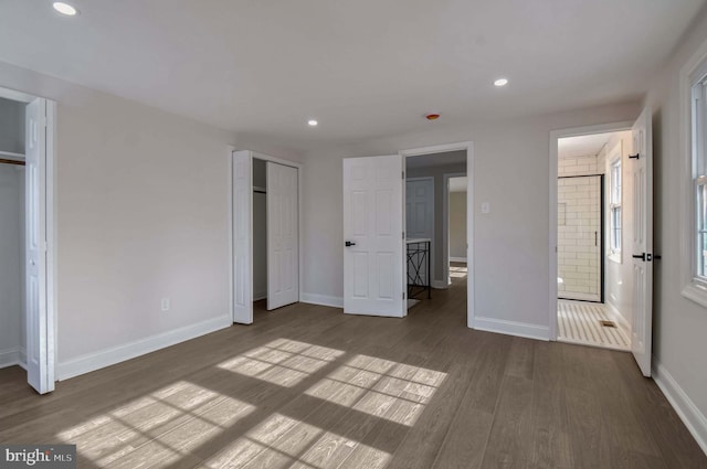 unfurnished bedroom with multiple closets, recessed lighting, baseboards, and wood finished floors