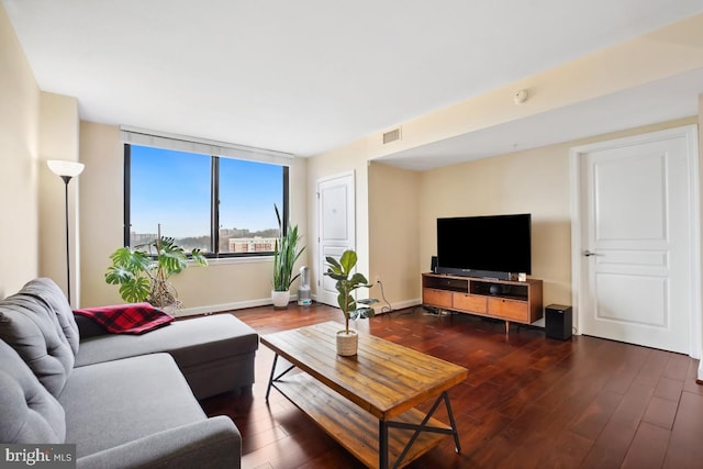 living room with dark wood-type flooring, visible vents, and baseboards