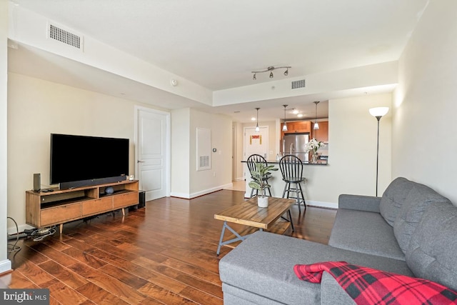 living area featuring visible vents, dark wood-type flooring, and baseboards