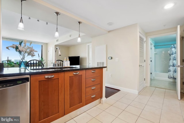 kitchen with baseboards, dishwasher, pendant lighting, light tile patterned floors, and brown cabinetry