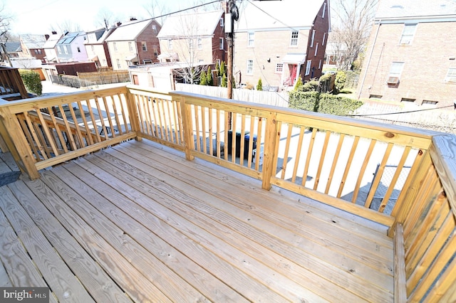 wooden terrace with a residential view and a fenced backyard