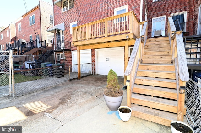 exterior space featuring brick siding, an attached garage, driveway, and fence