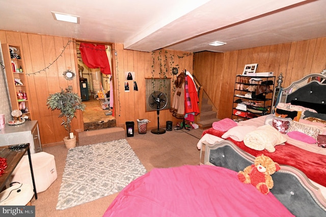 carpeted bedroom with wooden walls and water heater