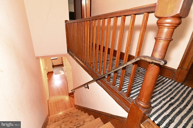 stairs with baseboards and wood finished floors