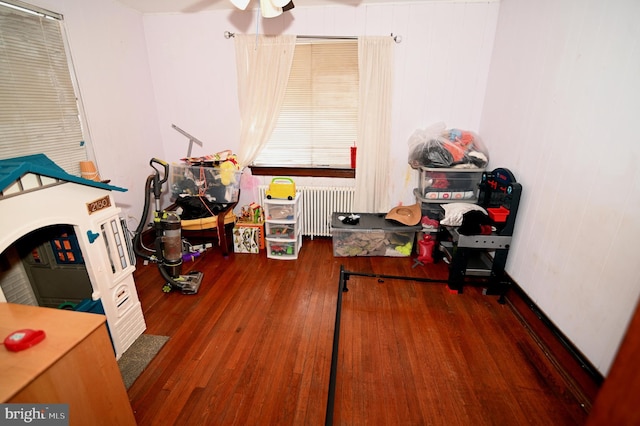 playroom featuring radiator, a ceiling fan, and wood-type flooring