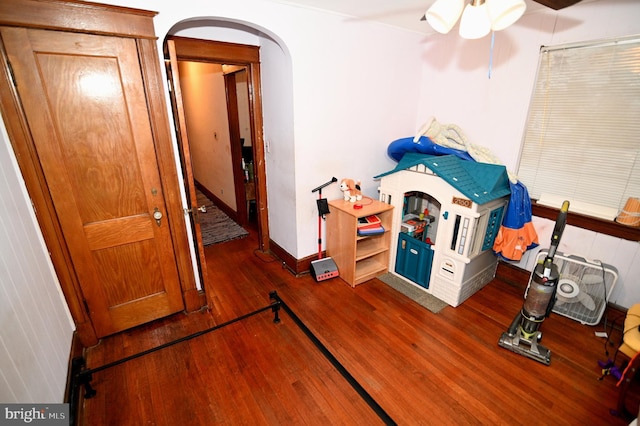 interior space featuring baseboards, arched walkways, and hardwood / wood-style floors