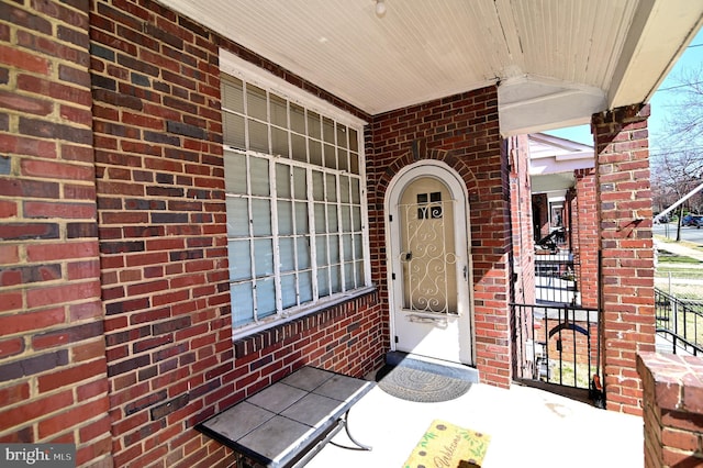 doorway to property featuring brick siding