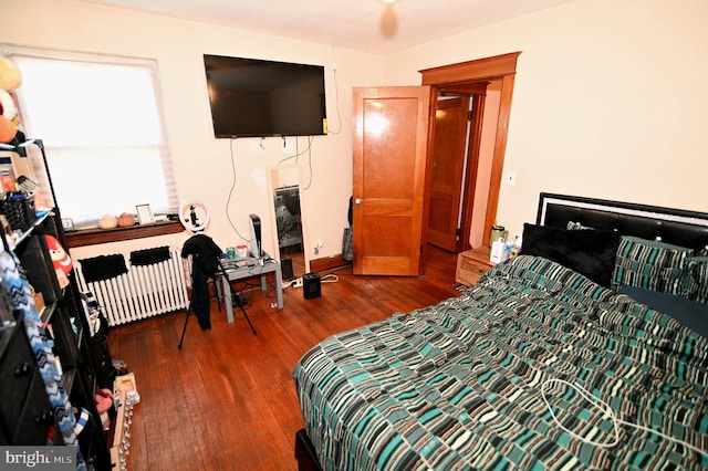 bedroom featuring radiator heating unit and wood finished floors