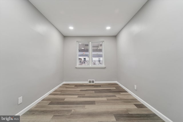 spare room featuring visible vents, recessed lighting, baseboards, and wood finished floors