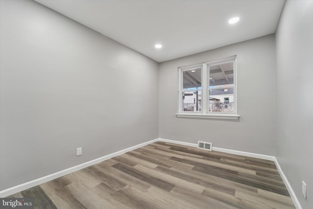 spare room with recessed lighting, visible vents, baseboards, and wood finished floors