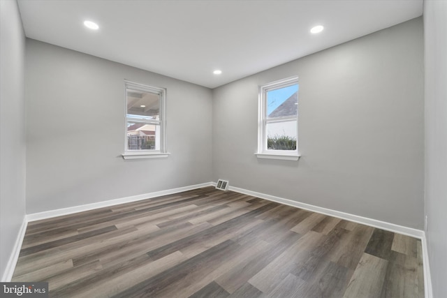 spare room featuring visible vents, recessed lighting, dark wood-type flooring, and baseboards