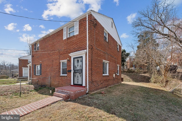 view of front facade featuring brick siding, a front lawn, and fence