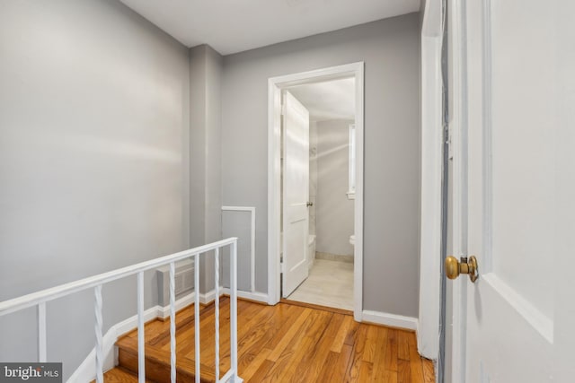 hall featuring light wood-style floors and baseboards