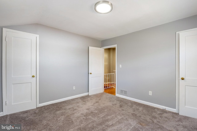 unfurnished bedroom with visible vents, carpet floors, and baseboards