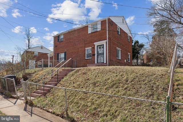 view of front facade with brick siding and fence