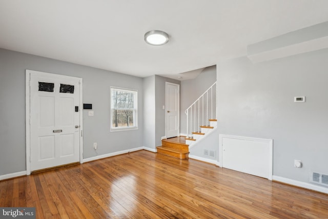 entrance foyer with baseboards, visible vents, and wood-type flooring