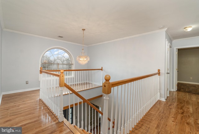 stairway featuring visible vents, baseboards, an inviting chandelier, and wood finished floors