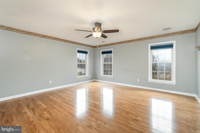 unfurnished room with baseboards, visible vents, light wood finished floors, and ceiling fan