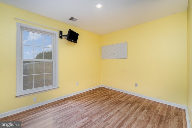 spare room featuring recessed lighting, wood finished floors, visible vents, and baseboards